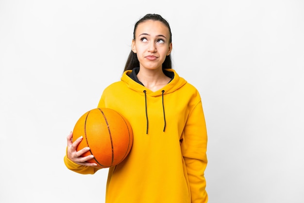 Jeune femme arabe jouant au basket-ball sur fond blanc isolé et levant les yeux