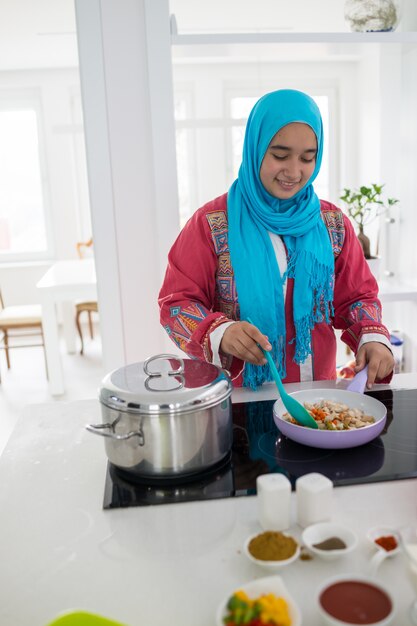 Jeune femme arabe musulmane dans la cuisine