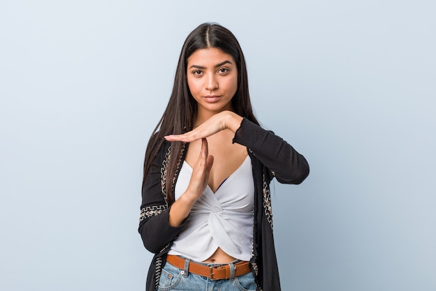 Jeune femme arabe naturelle et jolie montrant un geste de temporisation.