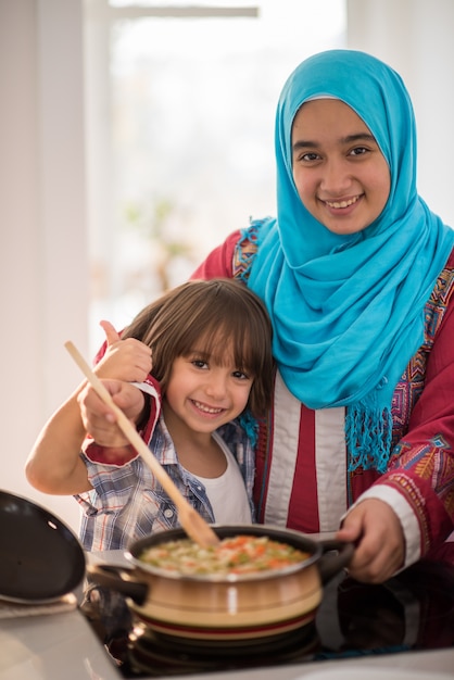 Jeune femme arabe avec petit enfant dans la cuisine