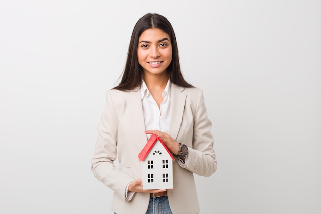 Jeune femme arabe tenant une icône de la maison heureuse, souriante et joyeuse.