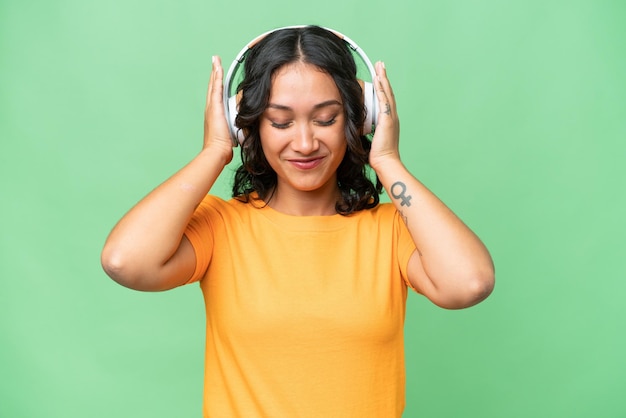 Jeune femme argentine caucasienne sur fond isolé écoutant de la musique