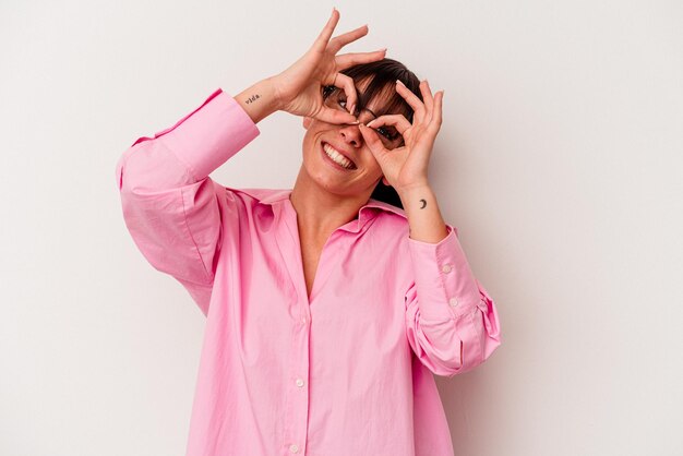 Jeune femme argentine isolée sur fond blanc montrant un signe correct sur les yeux