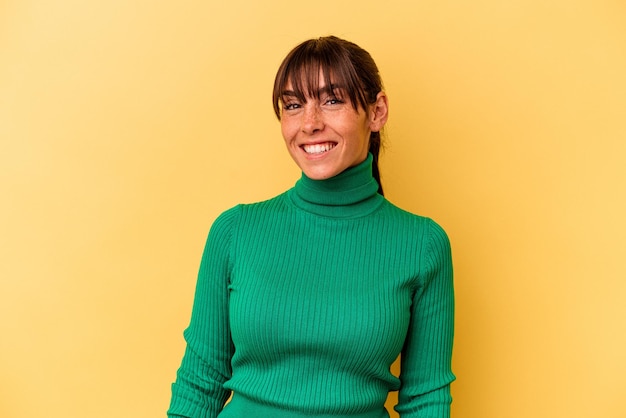 Jeune femme argentine isolée sur fond jaune heureuse, souriante et joyeuse.