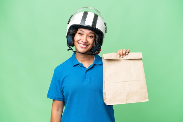 Jeune femme argentine prenant un sac de plats à emporter sur fond isolé souriant beaucoup