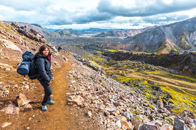 Une jeune femme arrivant à la vallée des cendres volcaniques du trek de 54 km de Landmannalaugar, Islande