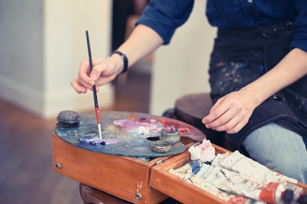 Jeune femme artiste travaillant sur la peinture en studio.