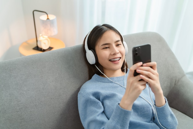 Jeune femme asiatique à l'aide de son téléphone et écouter de la musique