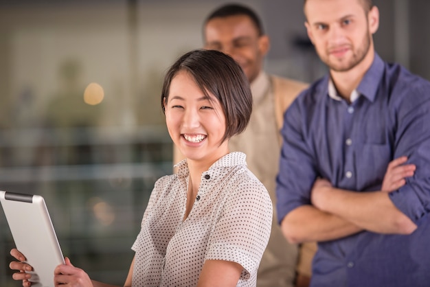 Jeune femme asiatique à l'aide de tablette et souriant