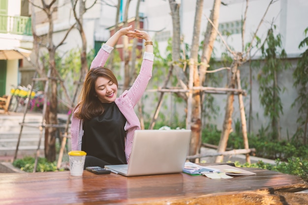 Jeune femme asiatique assis à table devant un ordinateur portable