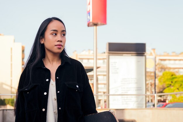 Jeune femme asiatique attend à la sortie de la station de métro, concept de mode de vie urbain