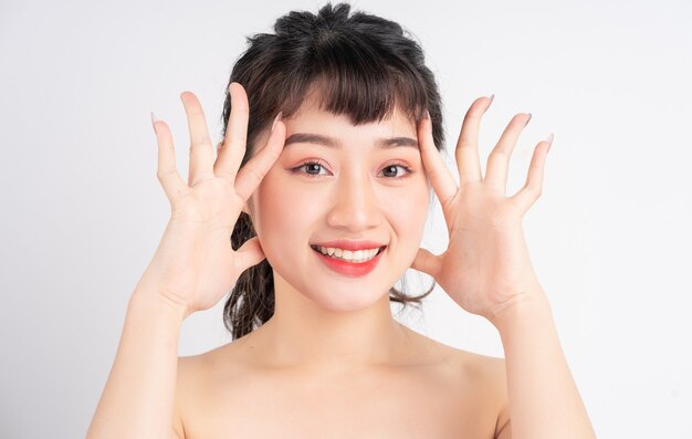 Jeune femme asiatique avec une belle peau sur fond blanc