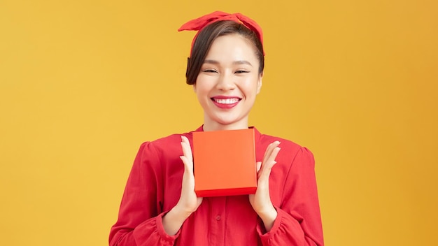 Une jeune femme asiatique avec une boîte à cadeaux.