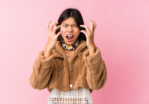 Jeune femme asiatique bouleversée crier avec des mains tendues.