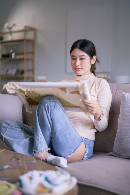 Jeune femme asiatique broderie fil sur tissu avec aiguille de perforation pour artisanat fait à la main dans le style de vie de passe-temps