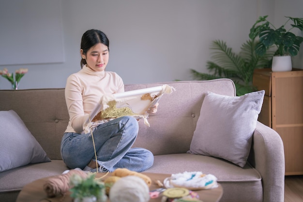 Photo jeune femme asiatique broderie fil sur tissu avec aiguille de punch pour l'artisanat fait à la main dans le style de vie de passe-temps