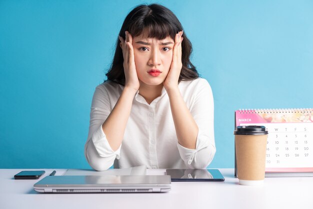 Jeune femme asiatique buisness travaillant sur bleu