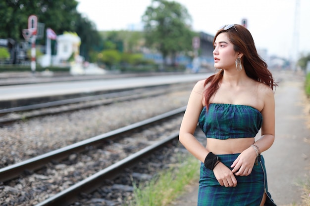 jeune femme asiatique cherche loin dans la gare avec visage beauté