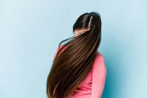 Jeune femme asiatique cheveux mobiles isolés sur fond bleu