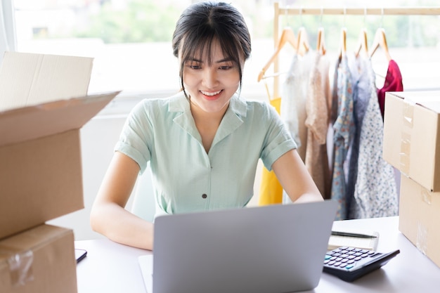 Jeune femme asiatique commençant une carrière de vente en ligne à domicile