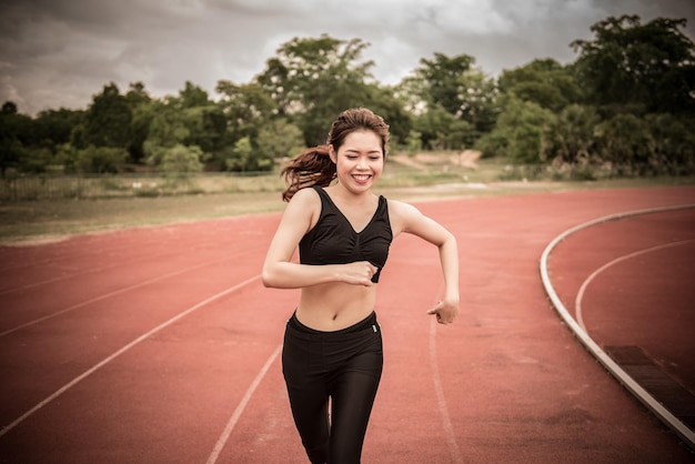 Jeune femme asiatique courir sur une piste de course