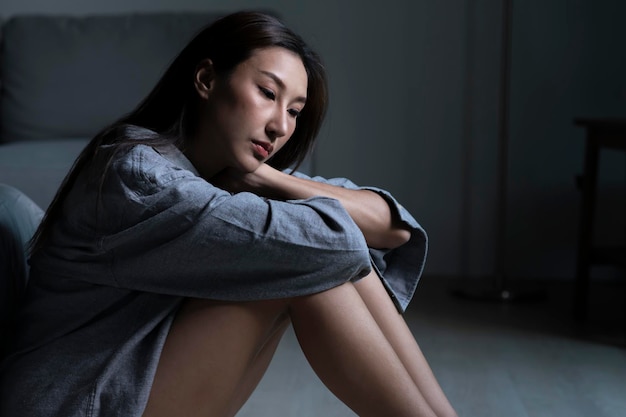 Jeune femme asiatique dans la chambre se sentant triste fatiguée et inquiète souffrant de dépression en santé mentale