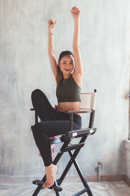 Jeune femme asiatique dans des vêtements sportifs, assis sur une chaise