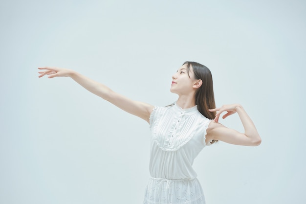 Jeune femme asiatique dansant gracieusement et fond blanc