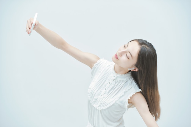 Jeune femme asiatique dansant tout en tenant un smartphone