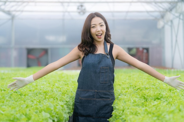 Jeune femme asiatique debout à la ferme hydroponique. Ferme maraîchère hydroponique. Concept de culture de légumes biologiques et d'aliments santé.
