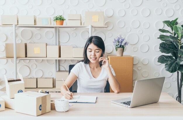 jeune femme asiatique démarrer propriétaire de petite entreprise travaillant avec une tablette numérique sur le lieu de travail.