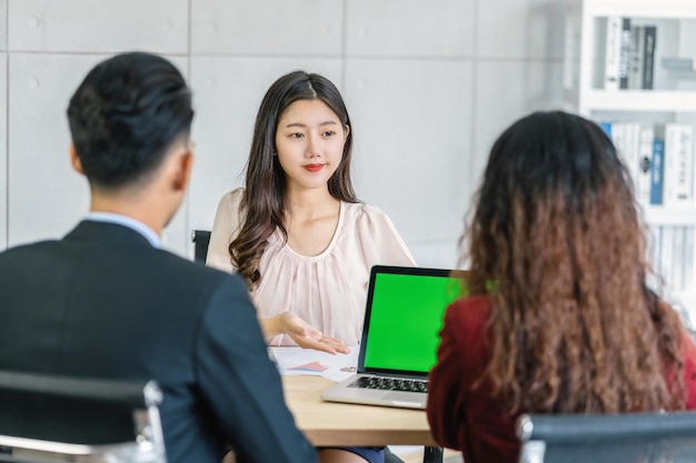 Jeune femme asiatique diplômée interviewant deux managers par présentation
