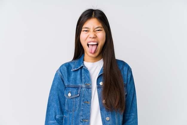 Jeune femme asiatique drôle et sympathique qui sort la langue.