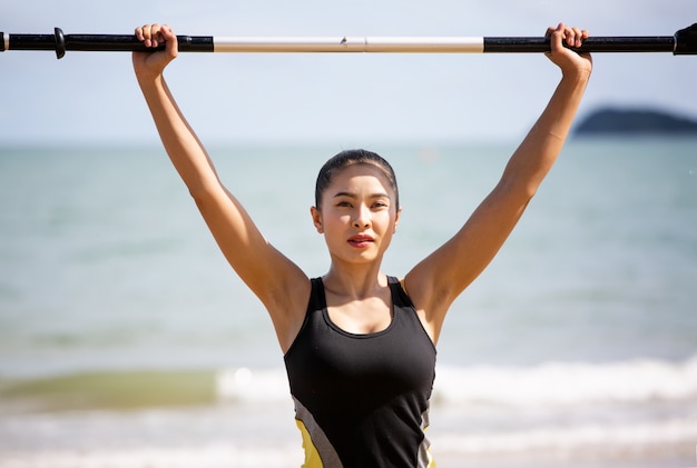 jeune femme asiatique exerce son corps sur la plage