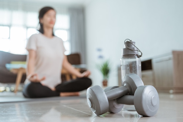 Jeune femme asiatique, faire des exercices à la maison par son autofocus sur haltère