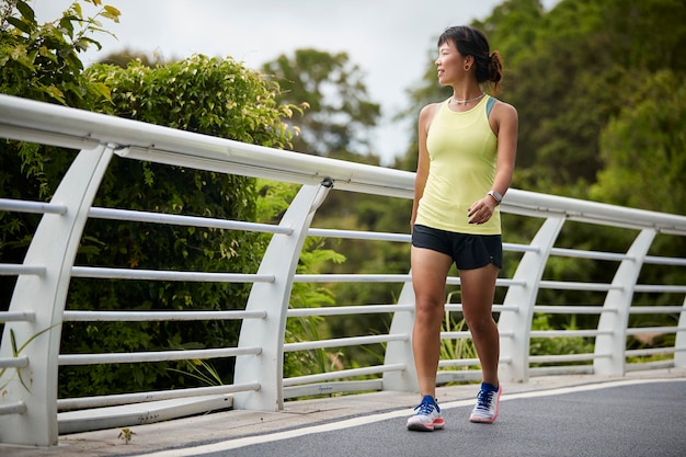 jeune femme asiatique faisant du jogging à l'extérieur dans le parc heureuse et souriante