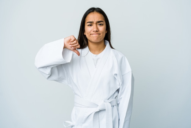 Jeune femme asiatique faisant du karaté isolé sur un mur blanc montrant un geste d'aversion, les pouces vers le bas. Concept de désaccord.