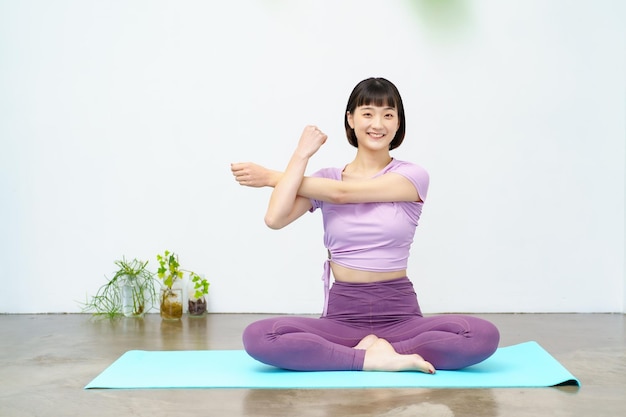 Jeune femme asiatique faisant du yoga et de l'exercice flexible