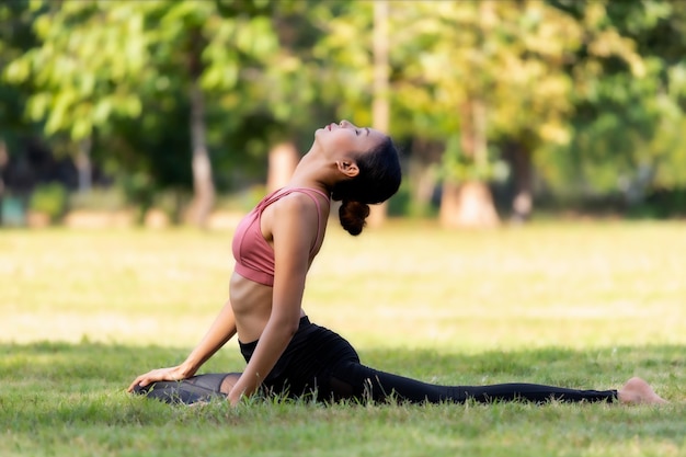 Jeune femme asiatique faisant du yoga le matin au parc