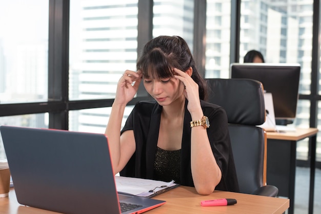 Jeune femme asiatique fatiguée et sérieuse de travailler