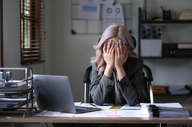 Jeune femme asiatique fatiguée et stressée assise sur son lieu de travail