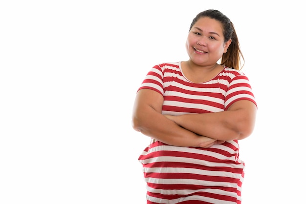 Jeune femme asiatique grasse heureuse souriant avec les bras croisés