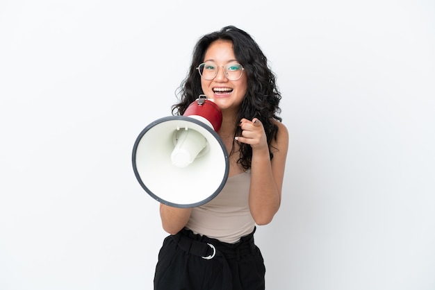 Jeune Femme Asiatique Isolée Sur Fond Blanc Criant à Travers Un Mégaphone Pour Annoncer Quelque Chose Tout En Pointant Vers L'avant