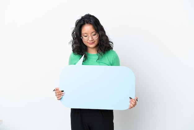 Jeune femme asiatique isolée sur fond blanc tenant une bulle de dialogue vide