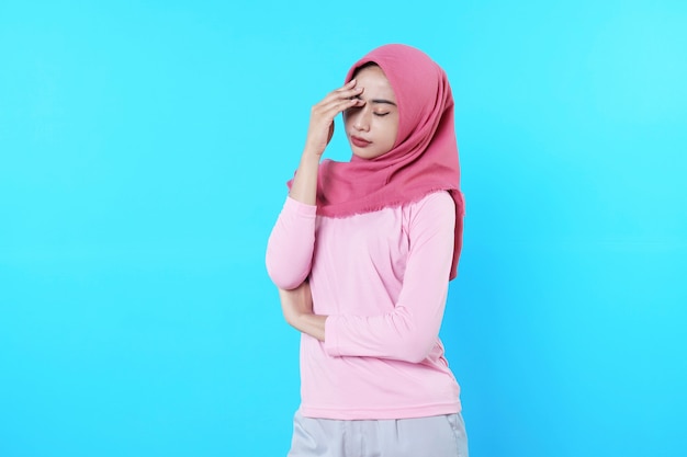 Jeune femme asiatique isolée sur fond bleu à la recherche d'une idée de réflexion et d'une expression douteuse