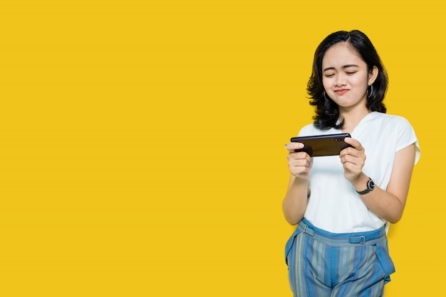 Jeune femme asiatique, jouer à des jeux sur smartphone