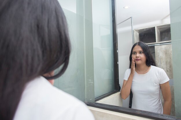 Jeune femme asiatique lave le visage dans la chambre