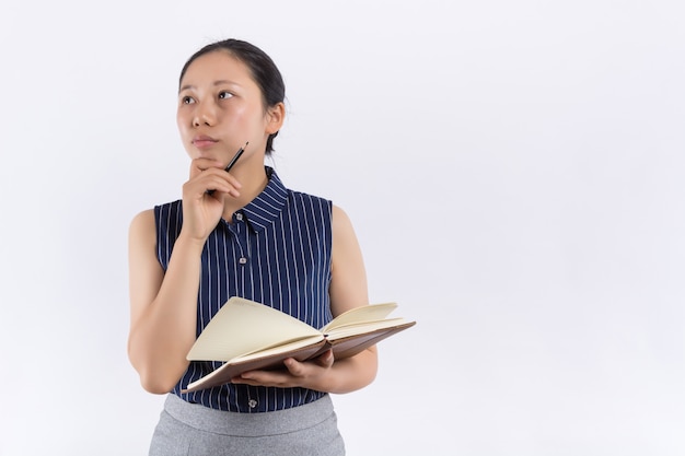 Jeune femme asiatique avec un livre couvre son visage