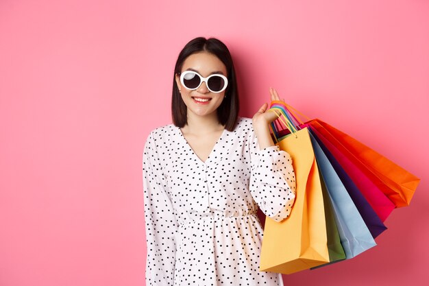 Jeune femme asiatique à lunettes de soleil faire du shopping