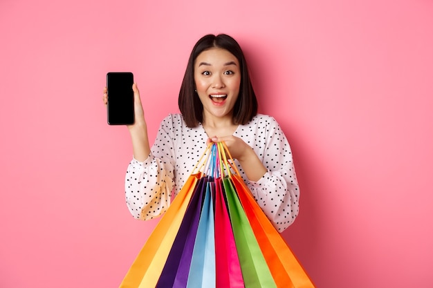 Jeune femme asiatique à lunettes de soleil faire du shopping